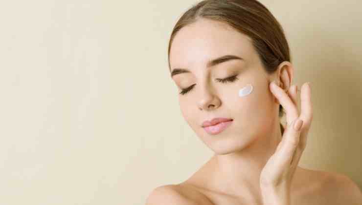 mujer poniéndose crema en la cara